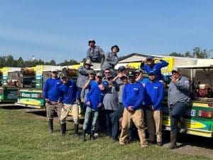 unnamsed Consolidated Pest Control team posing together outdoors at equipment display event